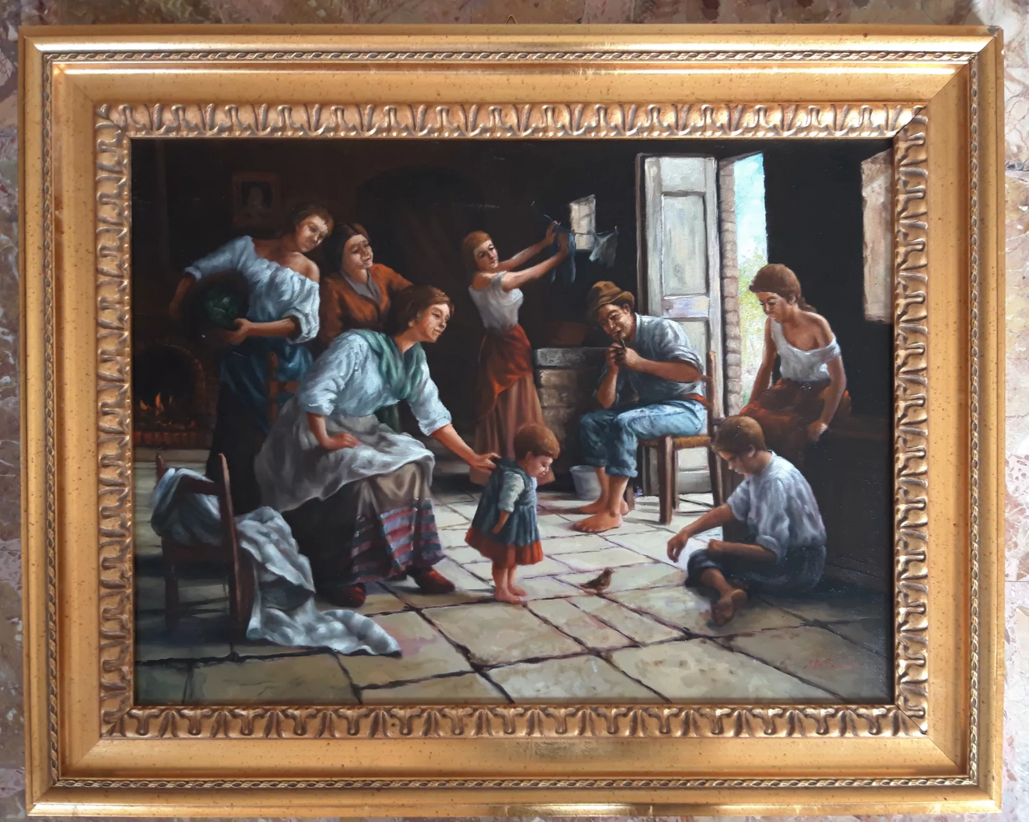 Bambina-con-passerotto-Aly-Mohsen "Quadro di Ay Mohsen realizzato ad Olio con pennello. Il titolo è Bambina con passerotto e rientra nella categoria C'era una volta. Con Bambina con passerotto, Aly Mohsen realizza una scena corale di intensa umanità, ambientata in un interno domestico popolare, dove la quotidianità si carica di valore simbolico e narrativo. Al centro della composizione, una bambina osserva con attenzione un piccolo passerotto posato sul pavimento: un gesto minimo che diventa metafora di innocenza, scoperta e fragilità della vita. Attorno alla figura infantile si sviluppa una narrazione familiare articolata e armonica. Le figure adulte, colte in attività diverse – lavoro, cura, attesa – costruiscono un tessuto umano continuo, fondato su solidarietà silenziosa e condivisione della fatica. La bambina non è isolata, ma inserita in una comunità che, pur nella povertà materiale, mantiene coesione, dignità e senso di appartenenza. La luce naturale che entra dalla porta aperta guida lo sguardo attraverso la scena, creando un equilibrato dialogo tra interno ed esterno. Questo impianto luministico rafforza la lettura etica dell’opera, in cui la ricchezza affettiva supera la precarietà delle condizioni materiali. La pittura è realista e controllata, con particolare attenzione ai dettagli quotidiani – piedi scalzi, tessuti consumati, posture naturali – restituiti senza idealizzazione. Il passerotto assume un forte valore simbolico, incarnando la vulnerabilità dell’esistenza affidata allo sguardo sensibile dell’infanzia. L’opera è completata da una cornice dorata originale, ampia e finemente lavorata, che conferisce al dipinto una presenza museale e crea un contrasto significativo con la semplicità dell’ambiente rappresentato. Opera figurativa originale di Aly Mohsen, Bambina con passerotto si inserisce nel ciclo dedicato alla vita popolare, alla famiglia e all’infanzia, rappresentando un esempio significativo di pittura narrativa contemporanea a forte contenuto umano e sociale."