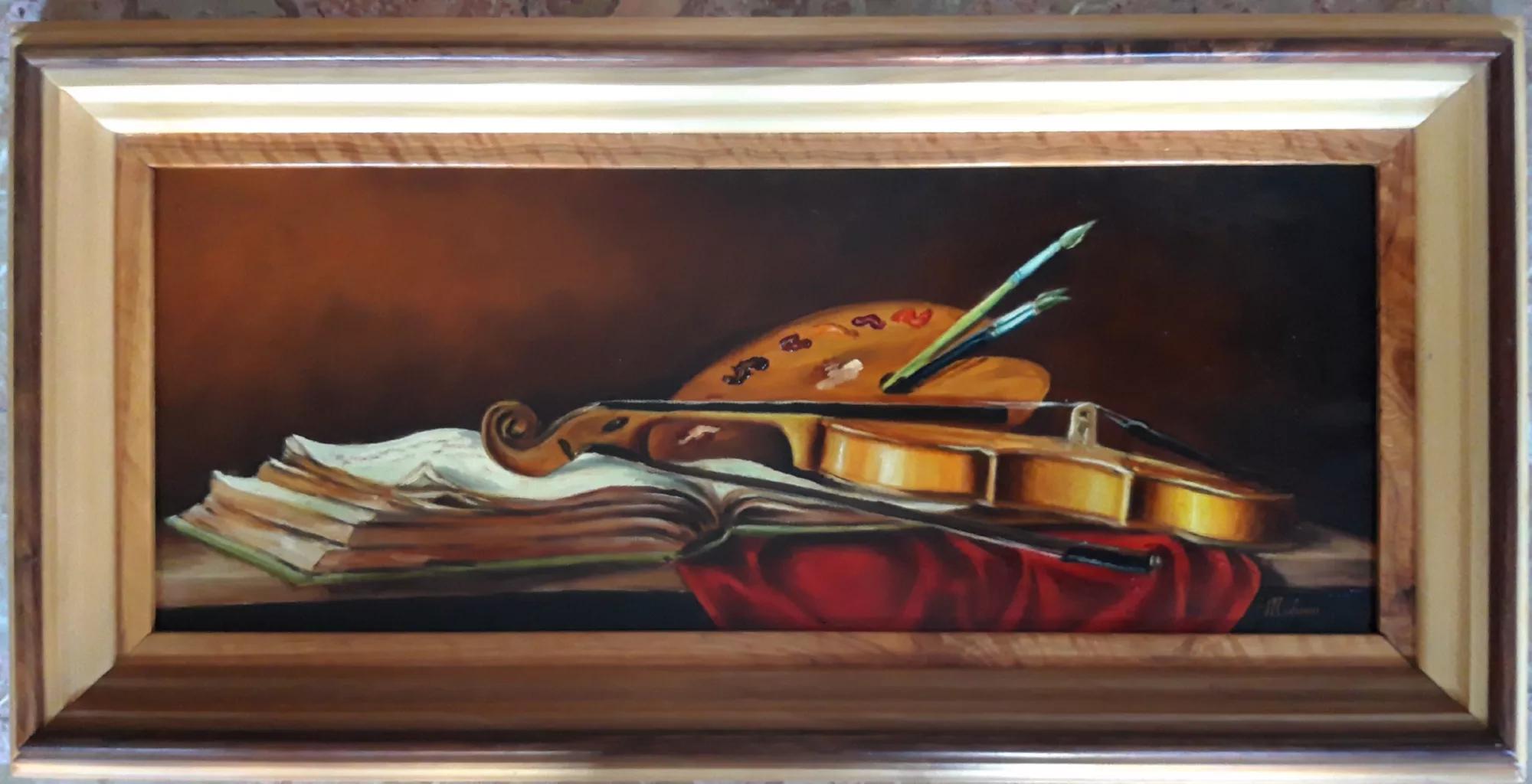 Le-tre-arti-Aly-Mohsen "Quadro di Ay Mohsen realizzato ad Olio con pennello. Il titolo è Le tre arti e rientra nella categoria Natura morta. Opera originale di Aly Mohsen, questa natura morta simbolica propone una riflessione visiva sul dialogo tra le arti, attraverso una composizione equilibrata e di forte coerenza formale. Al centro della scena è raffigurato un violino, disposto orizzontalmente su un libro aperto, mentre una tavolozza con pennelli poggia sullo strumento, stabilendo un chiaro rimando alla pittura figurativa e alla dimensione creativa dell’opera. La composizione si sviluppa secondo una struttura orizzontale misurata, nella quale ogni elemento è collocato con attenzione ai rapporti volumetrici e alle superfici. Il legno caldo del violino è reso con pennellate morbide e luminose, in contrasto con la carta leggermente ondulata del libro e con il tessuto rosso disposto in primo piano, che introduce un accento cromatico intenso e controllato. Il fondo scuro e gradualmente sfumato isola i soggetti, conferendo profondità e stabilità visiva all’insieme. La pittura, realizzata a pennello, evidenzia una solida padronanza tecnica e una sensibilità di impronta classica. La luce è calibrata con precisione per definire volumi, riflessi e materiali, mentre l’atmosfera complessiva risulta raccolta e contemplativa. L’opera si configura come una sintesi tra oggetti e significati, in cui musica, scrittura e pittura convivono in un’unica rappresentazione figurativa. Il dipinto è completato da una cornice ampia e strutturata, caratterizzata da tonalità calde e da un profilo interno chiaro che accompagna lo sguardo verso la composizione. La cornice rafforza la presenza formale dell’opera e ne offre una presentazione coerente e museale. Opera firmata e unica."