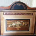 "Opera di Ay Mohsen realizzato con la tecnica dell'intarsio. Il titolo è Scrittoio della musica e rientra nella categoria Ebanisteria Monumentale. Questo straordinario Scrittoio della Musica, firmato Aly Mohsen, rappresenta uno dei vertici assoluti della sua produzione di ebanisteria artistica, in cui pittura, scultura e intarsio ligneo convivono in un unico oggetto funzionale e fortemente simbolico. L’opera si configura come un mobile scultoreo d’arte, concepito non come semplice arredo ma come opera autonoma, capace di dialogare con la tradizione delle arti applicate europee di alto livello. La struttura architettonica richiama con coerenza il linguaggio neoclassico e Impero, attraverso volumi pieni, una raffinata alzata centrale ad arco e colonne tornite coronate da capitelli in bronzo brunito, elementi che conferiscono solennità, ritmo e autorevolezza all’insieme. Il dialogo tra rigore formale e ricchezza decorativa costituisce uno dei tratti distintivi dell’opera. I pannelli frontali, laterali e posteriori sono impreziositi da intarsi figurativi a tema musicale e ornamentale: strumenti, spartiti, ghirlande e una raffinata composizione floreale in vaso, simboli universali di armonia, creatività e bellezza senza tempo. Particolarmente significativa è la decorazione del retro, concepita come un’opera completa e autonoma, scelta rara e consapevole che ribadisce la natura artistica totale dello scrittoio. Dal punto di vista materico, l’opera è realizzata attraverso una sapiente combinazione di radica di noce e radica di thuya, selezionate per la profondità cromatica e la vivacità delle venature. Acero, ebano e padouk sono impiegati per cornici, filettature e contrasti cromatici, mentre il pero definisce con eleganza la cornice dell’intarsio posteriore, introducendo una tonalità calda e luminosa che armonizza l’intera composizione. Il piano di scrittura estraibile, scandito da campiture scure e filetti chiari, incornicia un riquadro centrale intarsiato che funge da fulcro visivo e funzionale. I numerosi cassetti, perfettamente integrati nella struttura, testimoniano l’elevatissimo livello tecnico dell’artista e la sua capacità di coniugare complessità costruttiva ed equilibrio formale. Interamente realizzato a mano, senza alcun ricorso a processi industriali, lo Scrittoio della Musica si impone come testimonianza dell’alta ebanisteria artistica europea contemporanea, in cui si rinnova consapevolmente la grande tradizione delle arti applicate storiche. L’opera si colloca idealmente tra arte applicata, scultura funzionale e patrimonio culturale, risultando idonea a contesti museali, collezioni storiche e ambienti di rappresentanza di alto profilo culturale."