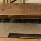 "Opera di Ay Mohsen realizzato con la tecnica dell'intarsio. Il titolo è Scrivania neoclassica e rientra nella categoria Ebanisteria Monumentale. Questa scrivania neoclassica intarsiata di Aly Mohsen si configura come opera di alta ebanisteria artistica, concepita come manufatto unitario in cui funzione e costruzione formale sono integrate in una struttura di carattere decorativo e architettonico. L’opera si colloca nel solco della tradizione dell’arredo classico europeo, riletta attraverso un controllo rigoroso dei materiali e della composizione. Il piano è realizzato in piuma di mogano selezionata, caratterizzata da una venatura simmetrica e continua che definisce una superficie compatta e visivamente coerente. L’area centrale è incorniciata da un articolato sistema di intarsi in acero chiaro, disposti secondo un disegno perimetrale di gusto neoclassico, con motivi floreali e fitomorfi collocati agli angoli e nei punti mediani dei lati. Il rapporto tra la decorazione intarsiata e la marezzatura naturale del mogano è costruito per continuità ritmica e bilanciamento visivo. I bordi del piano sono rifiniti in noce chiaro, introducendo un passaggio cromatico graduale tra superficie e struttura. Il corpo della scrivania e i cassetti sono realizzati in noce scuro, materiale che conferisce solidità visiva e coerenza tonale all’insieme, contribuendo alla lettura architettonica del mobile. Le gambe smontabili sono costruite con un’anima in mogano lamellare, successivamente rivestita in radica di quercia. Su ciascuna gamba sono presenti intarsi verticali in acero chiaro, impostati come elementi ornamentali continui che accentuano lo sviluppo verticale e il carattere scultoreo della struttura. Il bordo perimetrale del piano, trattato come cornice funzionale dell’intera composizione, svolge un ruolo di contenimento visivo e di definizione spaziale dell’opera, delimitando la superficie intarsiata e contribuendo alla stabilità formale e percettiva della scrivania.""Quadro di Ay Mohsen realizzato ad Intarsio. Il titolo è Scrivania neoclassica e rientra nella categoria Ebanisteria Monumentale. Questa scrivania neoclassica intarsiata di Aly Mohsen si configura come opera di alta ebanisteria artistica, concepita come manufatto unitario in cui funzione e costruzione formale sono integrate in una struttura di carattere decorativo e architettonico. L’opera si colloca nel solco della tradizione dell’arredo classico europeo, riletta attraverso un controllo rigoroso dei materiali e della composizione. Il piano è realizzato in piuma di mogano selezionata, caratterizzata da una venatura simmetrica e continua che definisce una superficie compatta e visivamente coerente. L’area centrale è incorniciata da un articolato sistema di intarsi in acero chiaro, disposti secondo un disegno perimetrale di gusto neoclassico, con motivi floreali e fitomorfi collocati agli angoli e nei punti mediani dei lati. Il rapporto tra la decorazione intarsiata e la marezzatura naturale del mogano è costruito per continuità ritmica e bilanciamento visivo. I bordi del piano sono rifiniti in noce chiaro, introducendo un passaggio cromatico graduale tra superficie e struttura. Il corpo della scrivania e i cassetti sono realizzati in noce scuro, materiale che conferisce solidità visiva e coerenza tonale all’insieme, contribuendo alla lettura architettonica del mobile. Le gambe smontabili sono costruite con un’anima in mogano lamellare, successivamente rivestita in radica di quercia. Su ciascuna gamba sono presenti intarsi verticali in acero chiaro, impostati come elementi ornamentali continui che accentuano lo sviluppo verticale e il carattere scultoreo della struttura. Il bordo perimetrale del piano, trattato come cornice funzionale dell’intera composizione, svolge un ruolo di contenimento visivo e di definizione spaziale dell’opera, delimitando la superficie intarsiata e contribuendo alla stabilità formale e percettiva della scrivania.""Quadro di Ay Mohsen realizzato ad Intarsio. Il titolo è Scrivania neoclassica e rientra nella categoria Ebanisteria Monumentale. Questa scrivania neoclassica intarsiata di Aly Mohsen si configura come opera di alta ebanisteria artistica, concepita come manufatto unitario in cui funzione e costruzione formale sono integrate in una struttura di carattere decorativo e architettonico. L’opera si colloca nel solco della tradizione dell’arredo classico europeo, riletta attraverso un controllo rigoroso dei materiali e della composizione. Il piano è realizzato in piuma di mogano selezionata, caratterizzata da una venatura simmetrica e continua che definisce una superficie compatta e visivamente coerente. L’area centrale è incorniciata da un articolato sistema di intarsi in acero chiaro, disposti secondo un disegno perimetrale di gusto neoclassico, con motivi floreali e fitomorfi collocati agli angoli e nei punti mediani dei lati. Il rapporto tra la decorazione intarsiata e la marezzatura naturale del mogano è costruito per continuità ritmica e bilanciamento visivo. I bordi del piano sono rifiniti in noce chiaro, introducendo un passaggio cromatico graduale tra superficie e struttura. Il corpo della scrivania e i cassetti sono realizzati in noce scuro, materiale che conferisce solidità visiva e coerenza tonale all’insieme, contribuendo alla lettura architettonica del mobile. Le gambe smontabili sono costruite con un’anima in mogano lamellare, successivamente rivestita in radica di quercia. Su ciascuna gamba sono presenti intarsi verticali in acero chiaro, impostati come elementi ornamentali continui che accentuano lo sviluppo verticale e il carattere scultoreo della struttura. Il bordo perimetrale del piano, trattato come cornice funzionale dell’intera composizione, svolge un ruolo di contenimento visivo e di definizione spaziale dell’opera, delimitando la superficie intarsiata e contribuendo alla stabilità formale e percettiva della scrivania."