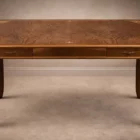 "Opera di Ay Mohsen realizzato con la tecnica dell'intarsio. Il titolo è Scrivania neoclassica e rientra nella categoria Ebanisteria Monumentale. Questa scrivania neoclassica intarsiata di Aly Mohsen si configura come opera di alta ebanisteria artistica, concepita come manufatto unitario in cui funzione e costruzione formale sono integrate in una struttura di carattere decorativo e architettonico. L’opera si colloca nel solco della tradizione dell’arredo classico europeo, riletta attraverso un controllo rigoroso dei materiali e della composizione. Il piano è realizzato in piuma di mogano selezionata, caratterizzata da una venatura simmetrica e continua che definisce una superficie compatta e visivamente coerente. L’area centrale è incorniciata da un articolato sistema di intarsi in acero chiaro, disposti secondo un disegno perimetrale di gusto neoclassico, con motivi floreali e fitomorfi collocati agli angoli e nei punti mediani dei lati. Il rapporto tra la decorazione intarsiata e la marezzatura naturale del mogano è costruito per continuità ritmica e bilanciamento visivo. I bordi del piano sono rifiniti in noce chiaro, introducendo un passaggio cromatico graduale tra superficie e struttura. Il corpo della scrivania e i cassetti sono realizzati in noce scuro, materiale che conferisce solidità visiva e coerenza tonale all’insieme, contribuendo alla lettura architettonica del mobile. Le gambe smontabili sono costruite con un’anima in mogano lamellare, successivamente rivestita in radica di quercia. Su ciascuna gamba sono presenti intarsi verticali in acero chiaro, impostati come elementi ornamentali continui che accentuano lo sviluppo verticale e il carattere scultoreo della struttura. Il bordo perimetrale del piano, trattato come cornice funzionale dell’intera composizione, svolge un ruolo di contenimento visivo e di definizione spaziale dell’opera, delimitando la superficie intarsiata e contribuendo alla stabilità formale e percettiva della scrivania.""Quadro di Ay Mohsen realizzato ad Intarsio. Il titolo è Scrivania neoclassica e rientra nella categoria Ebanisteria Monumentale. Questa scrivania neoclassica intarsiata di Aly Mohsen si configura come opera di alta ebanisteria artistica, concepita come manufatto unitario in cui funzione e costruzione formale sono integrate in una struttura di carattere decorativo e architettonico. L’opera si colloca nel solco della tradizione dell’arredo classico europeo, riletta attraverso un controllo rigoroso dei materiali e della composizione. Il piano è realizzato in piuma di mogano selezionata, caratterizzata da una venatura simmetrica e continua che definisce una superficie compatta e visivamente coerente. L’area centrale è incorniciata da un articolato sistema di intarsi in acero chiaro, disposti secondo un disegno perimetrale di gusto neoclassico, con motivi floreali e fitomorfi collocati agli angoli e nei punti mediani dei lati. Il rapporto tra la decorazione intarsiata e la marezzatura naturale del mogano è costruito per continuità ritmica e bilanciamento visivo. I bordi del piano sono rifiniti in noce chiaro, introducendo un passaggio cromatico graduale tra superficie e struttura. Il corpo della scrivania e i cassetti sono realizzati in noce scuro, materiale che conferisce solidità visiva e coerenza tonale all’insieme, contribuendo alla lettura architettonica del mobile. Le gambe smontabili sono costruite con un’anima in mogano lamellare, successivamente rivestita in radica di quercia. Su ciascuna gamba sono presenti intarsi verticali in acero chiaro, impostati come elementi ornamentali continui che accentuano lo sviluppo verticale e il carattere scultoreo della struttura. Il bordo perimetrale del piano, trattato come cornice funzionale dell’intera composizione, svolge un ruolo di contenimento visivo e di definizione spaziale dell’opera, delimitando la superficie intarsiata e contribuendo alla stabilità formale e percettiva della scrivania.""Quadro di Ay Mohsen realizzato ad Intarsio. Il titolo è Scrivania neoclassica e rientra nella categoria Ebanisteria Monumentale. Questa scrivania neoclassica intarsiata di Aly Mohsen si configura come opera di alta ebanisteria artistica, concepita come manufatto unitario in cui funzione e costruzione formale sono integrate in una struttura di carattere decorativo e architettonico. L’opera si colloca nel solco della tradizione dell’arredo classico europeo, riletta attraverso un controllo rigoroso dei materiali e della composizione. Il piano è realizzato in piuma di mogano selezionata, caratterizzata da una venatura simmetrica e continua che definisce una superficie compatta e visivamente coerente. L’area centrale è incorniciata da un articolato sistema di intarsi in acero chiaro, disposti secondo un disegno perimetrale di gusto neoclassico, con motivi floreali e fitomorfi collocati agli angoli e nei punti mediani dei lati. Il rapporto tra la decorazione intarsiata e la marezzatura naturale del mogano è costruito per continuità ritmica e bilanciamento visivo. I bordi del piano sono rifiniti in noce chiaro, introducendo un passaggio cromatico graduale tra superficie e struttura. Il corpo della scrivania e i cassetti sono realizzati in noce scuro, materiale che conferisce solidità visiva e coerenza tonale all’insieme, contribuendo alla lettura architettonica del mobile. Le gambe smontabili sono costruite con un’anima in mogano lamellare, successivamente rivestita in radica di quercia. Su ciascuna gamba sono presenti intarsi verticali in acero chiaro, impostati come elementi ornamentali continui che accentuano lo sviluppo verticale e il carattere scultoreo della struttura. Il bordo perimetrale del piano, trattato come cornice funzionale dell’intera composizione, svolge un ruolo di contenimento visivo e di definizione spaziale dell’opera, delimitando la superficie intarsiata e contribuendo alla stabilità formale e percettiva della scrivania."